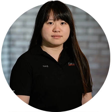 A female grad student poses in a Grey polo that reads deep orange