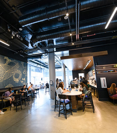 Students sit at tables in Starbucks in the Hub, a dining spot in Douthit Hills.