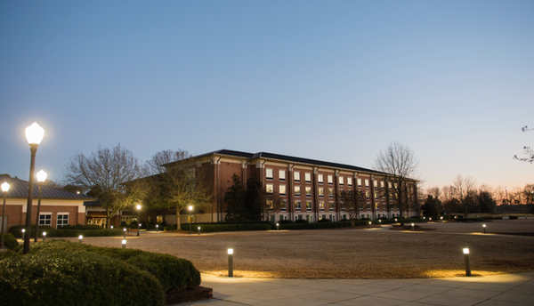 The exterior of a brick hotel at dusk.
