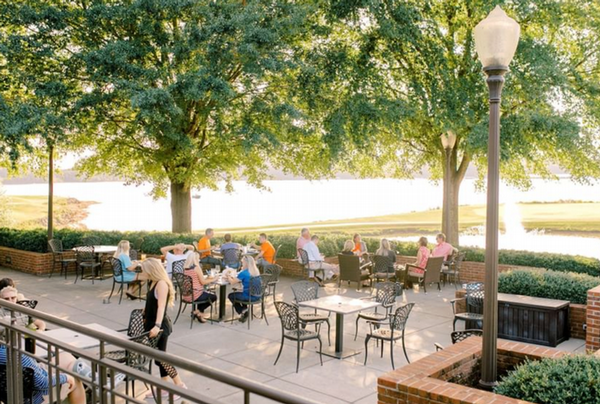People sit at tables at an outdoor courtyard.