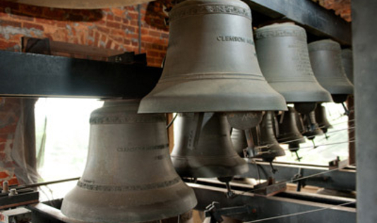 Carillon bells inside of a brick belltower.
