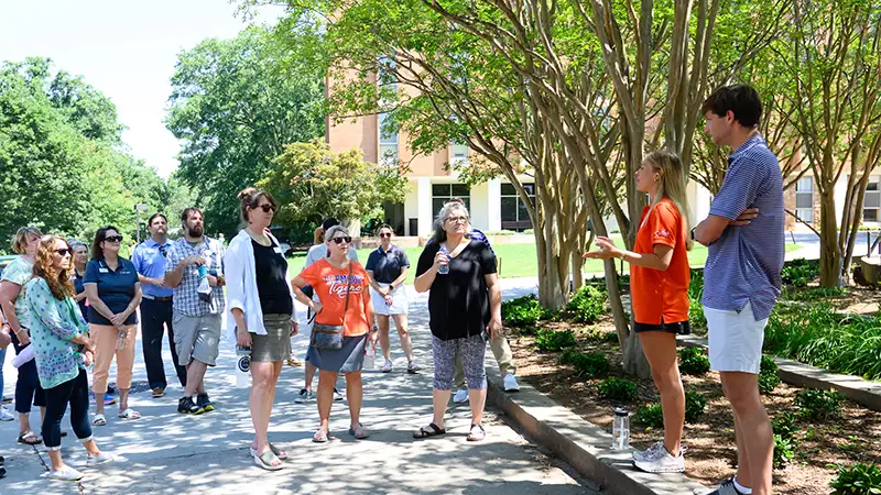 Two Clemson tour guides lead a group on a campus tour