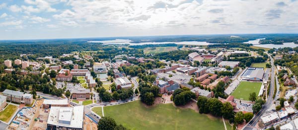 A wide-angle bird's-eye view of the Clemson University campus showing academic buildings, residence halls, athletic fields and Lake Hartwell.